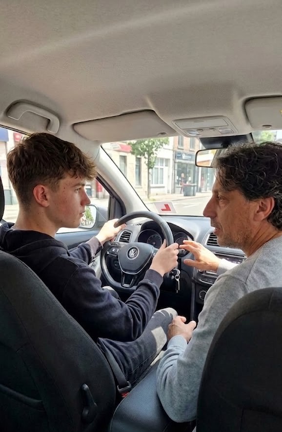 Emi explicándole el uso del volante a un alumno durante una clase de manejo a domicilio en su VW Polo automático