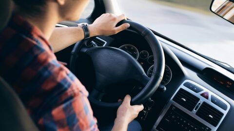 Persona principiante manejando con las dos manos sobre el volante de su auto